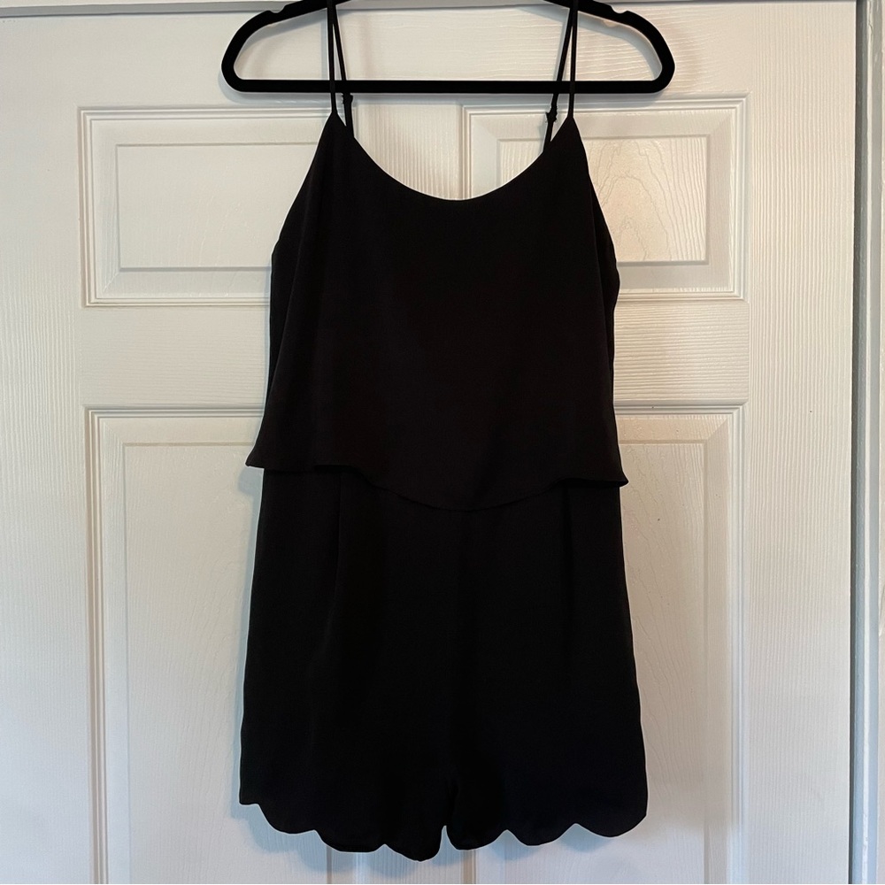 Black scalloped romper with adjustable straps and pockets